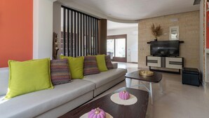 A modern living room with a sofa, coffee table, and TV stand.