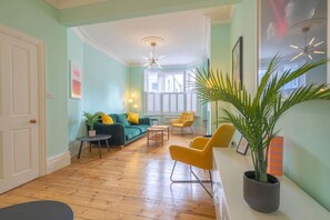 A living room with a green sofa, yellow chairs, a coffee table, and a potted plant. - Broadstairs ColourPop | Parking | Beach/Bars 2 min (Kent)