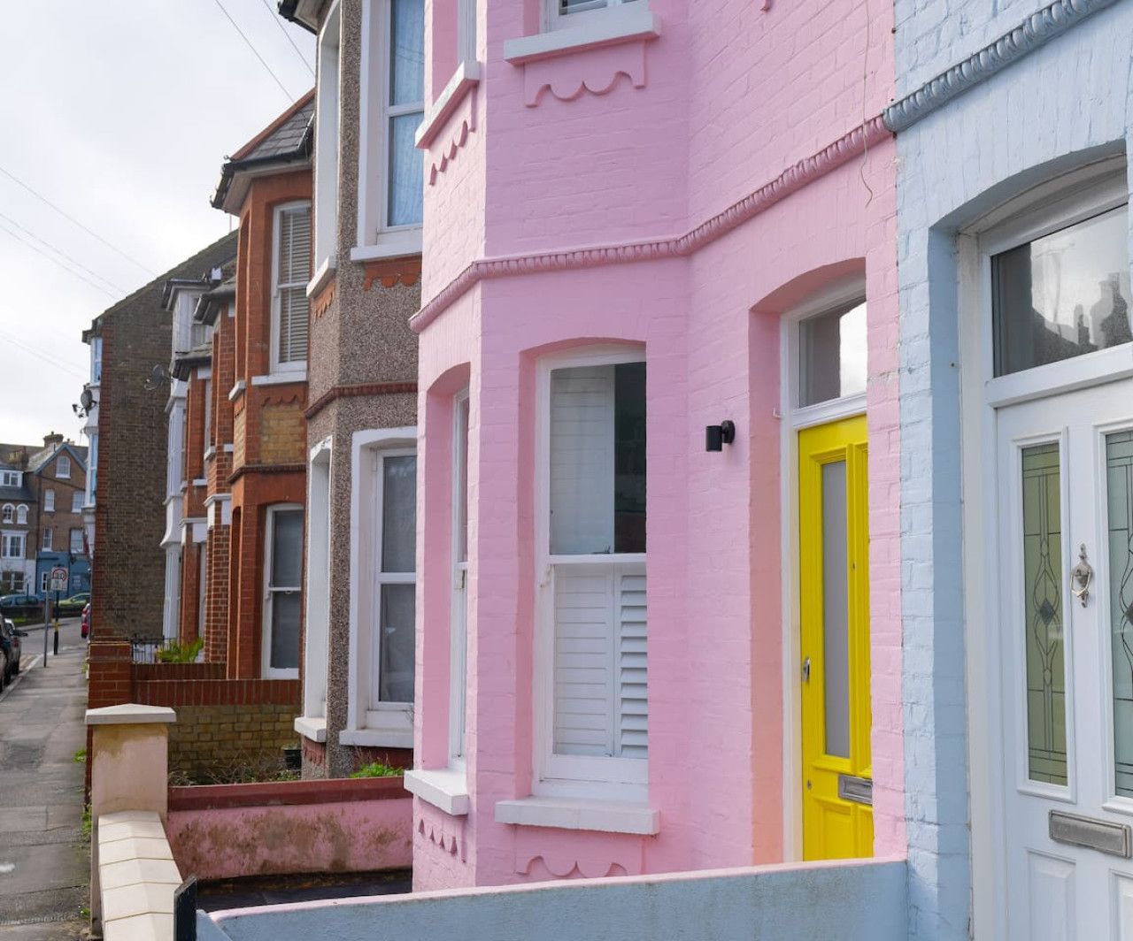 A row of terraced houses with distinct pastel-colored facades.