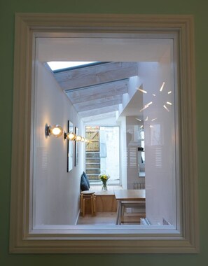 A narrow hallway with a skylight, wooden ceiling, and a dining area with a table and chairs. - Broadstairs ColourPop | Parking | Beach/Bars 2 min (Kent)