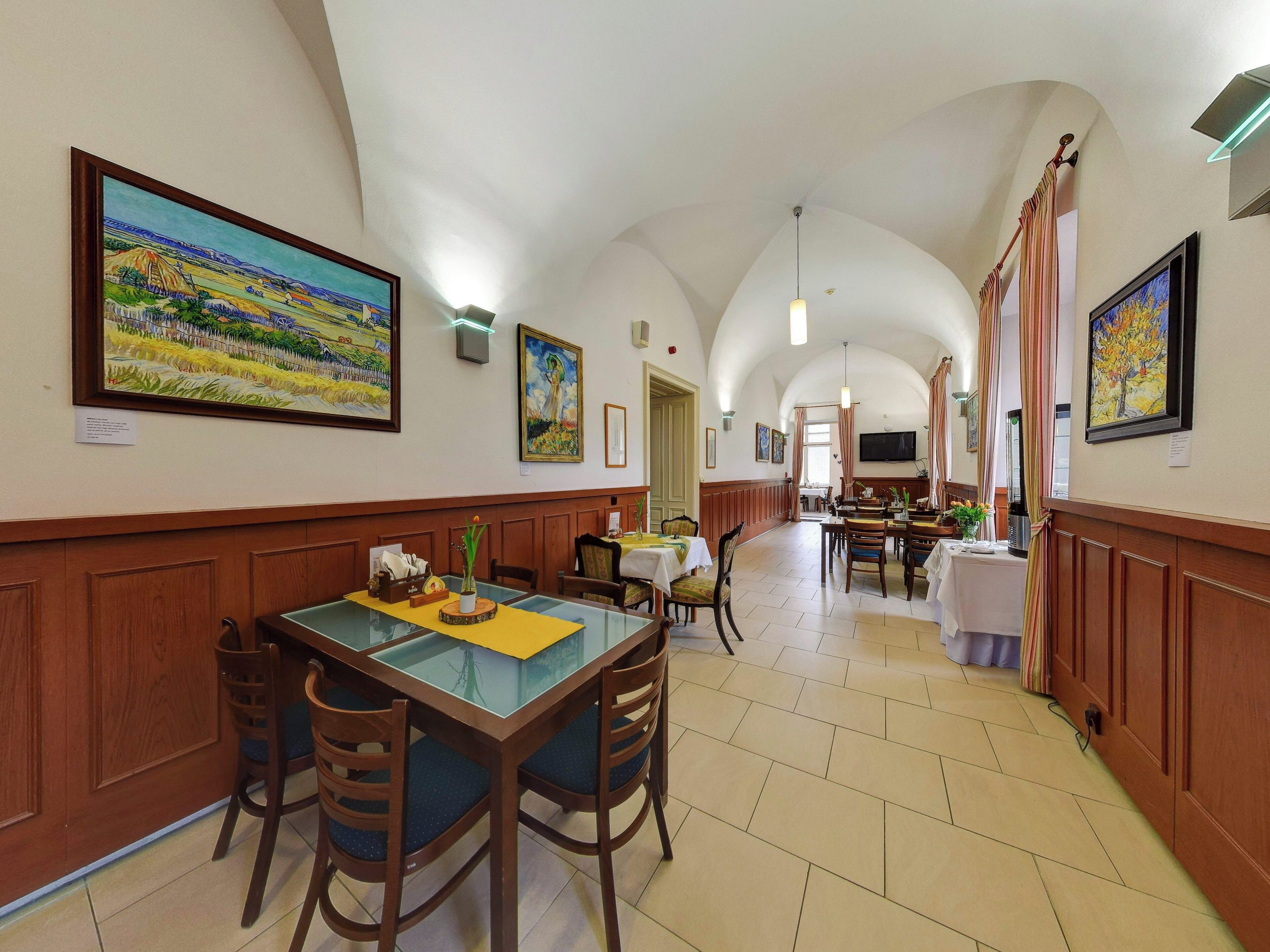 Un comedor con una mesa larga, sillas y vistas de la habitación contigua.