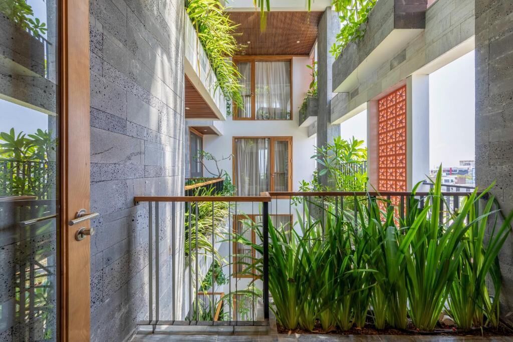 A modern interior with a concrete wall, a wooden railing, and green plants.