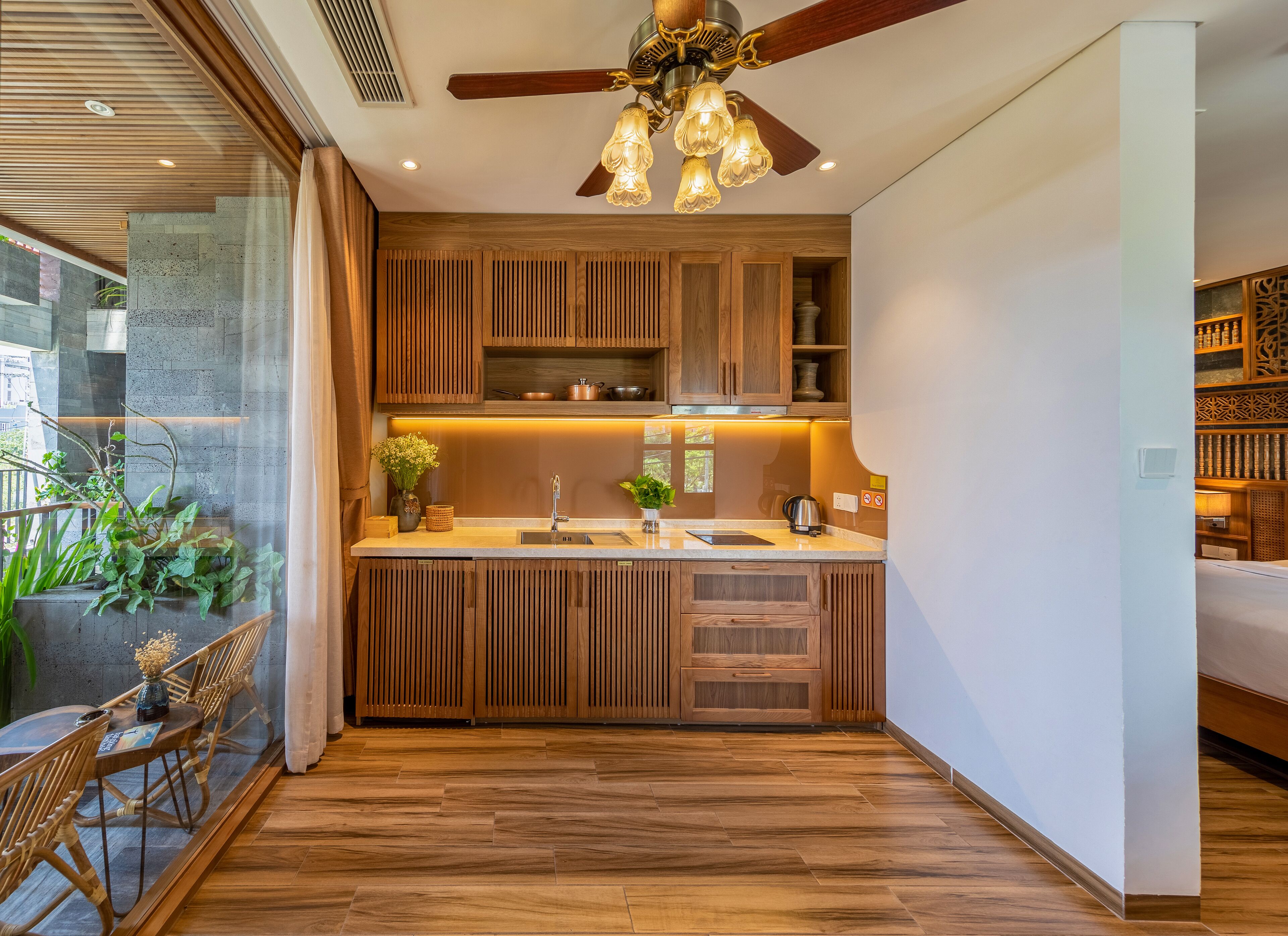 A modern kitchen with wooden cabinetry, a built-in island, and a ceiling fan.