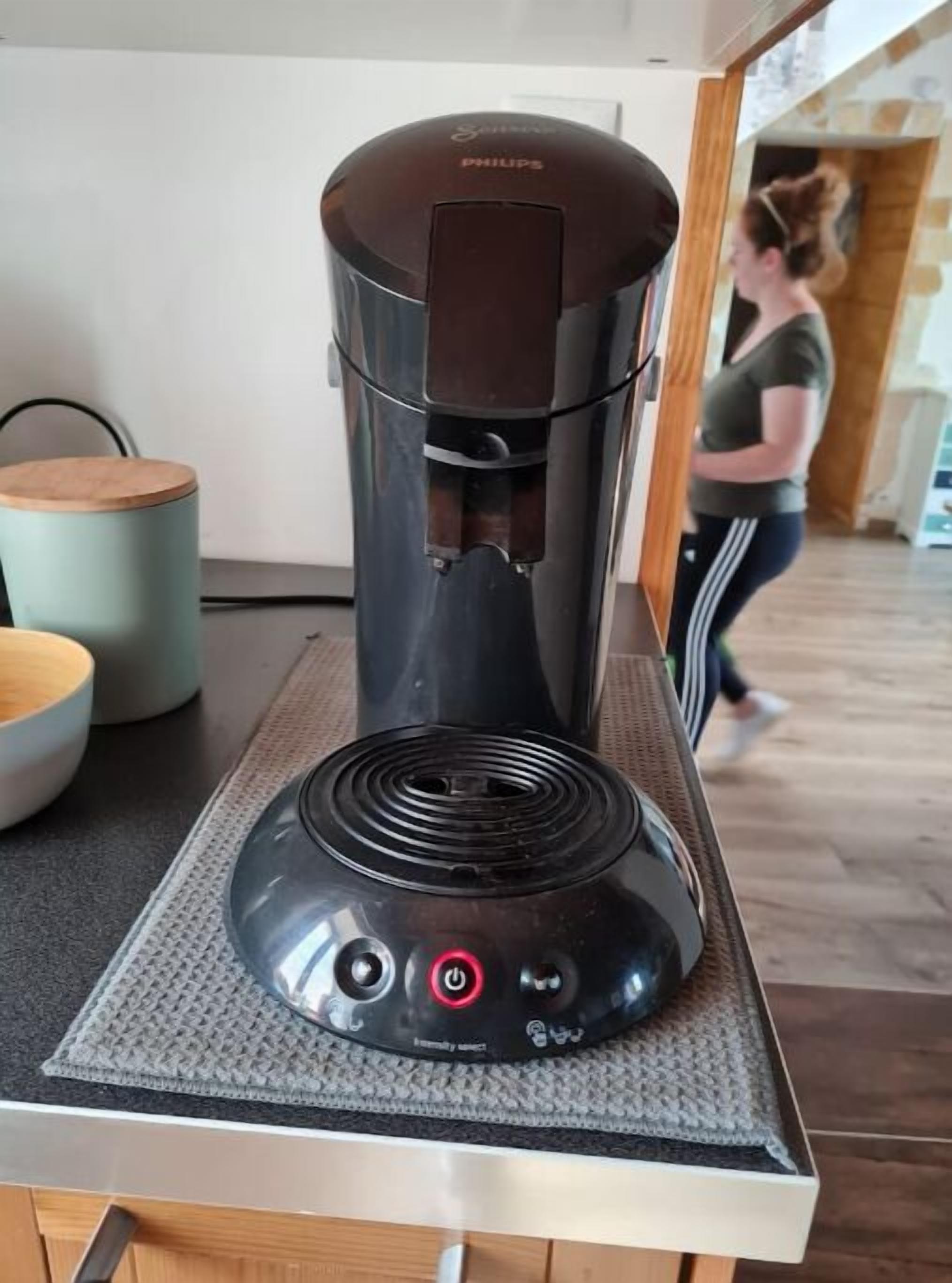 En kaffebryggare står på en köksbänk, med en strömbrytare och en kontrollpanel.