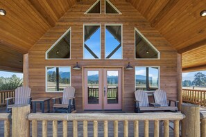 A wooden cabin with a porch, two Adirondack chairs, and a door with a view of the mountains. - * * *Como Peaks Cabin* * * (Hamilton)