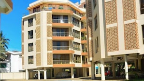 Un hôtel à plusieurs étages doté de balcons, d’un parking couvert et d’une piscine.
