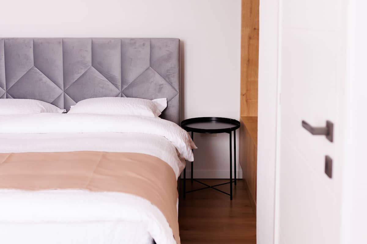 Ein Schlafzimmer mit Bett, Nachttisch und Tür.