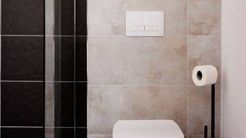 Appartement Deluxe | Salle de bain | Douche, douche à « effet pluie », sèche-cheveux, peignoirs