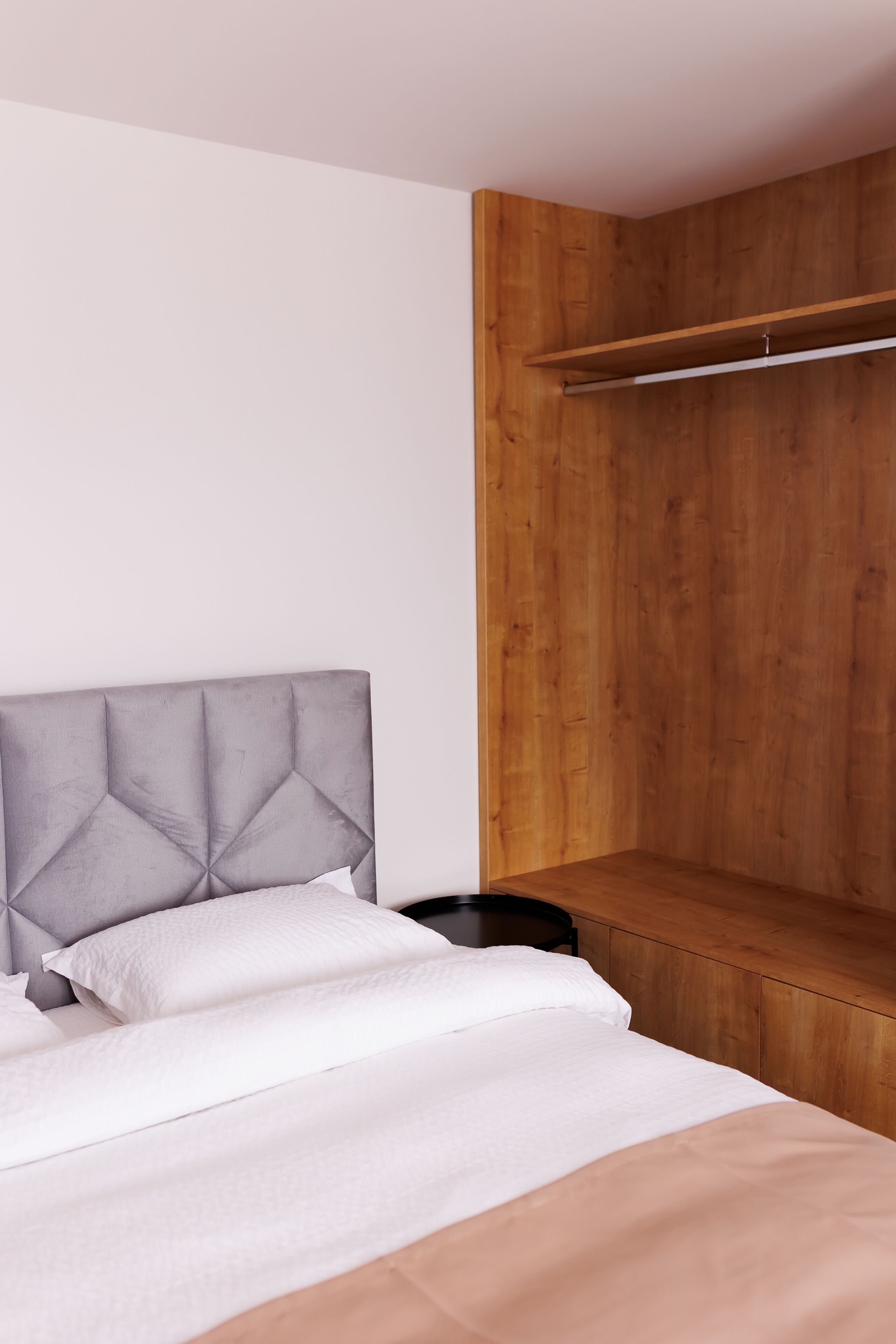A bedroom with a bed, a wooden headboard, and a wooden wall panel.