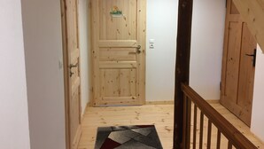 A wooden door with a small sticker, a wooden staircase, and a patterned rug on a wooden floor. - Ferienhof Wäldle 2 Balderschwang - Direkt an der Loipe mit Motorradvermietung (Balderschwang)