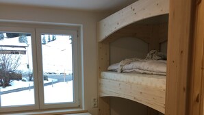 A room with a bunk bed, a window, and a wooden bench. - Ferienhof Wäldle 2 Balderschwang - Direkt an der Loipe mit Motorradvermietung (Balderschwang)