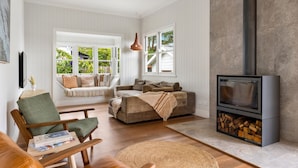A living room with a fireplace, a sofa, a chair, and a television.