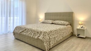 A bedroom with a bed, two bedside lamps, and a nightstand. - Casa Brina By Home080 (Monopoli)