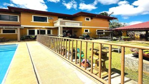 Un bâtiment à deux étages doté d’une piscine et d’une terrasse clôturée.
