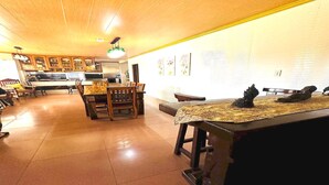 Une cuisine spacieuse avec des meubles en bois, un coin repas comprenant une table et des chaises, et un comptoir-bar agrémenté d’un objet décoratif.