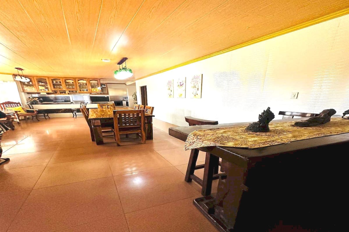A spacious kitchen with wooden cabinets, a dining area with a table and chairs, and a bar counter with a decorative item.
