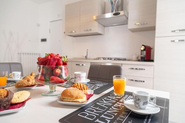 A breakfast table with pastries, a fruit bowl, and a coffee cup.