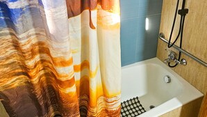 A bathroom with a shower, a bathtub, and a curtain with a marbled pattern. - Unique City Rooms (Larnaca)
