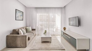 Una sala de estar moderna con un sofá, una mesa de centro y un televisor.