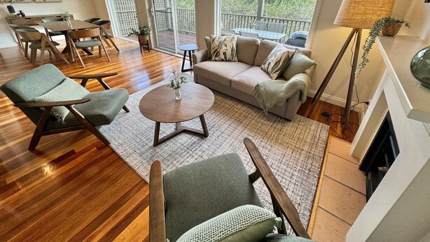 A spacious living area with a sofa, chairs, a coffee table, and a view of the outdoors.