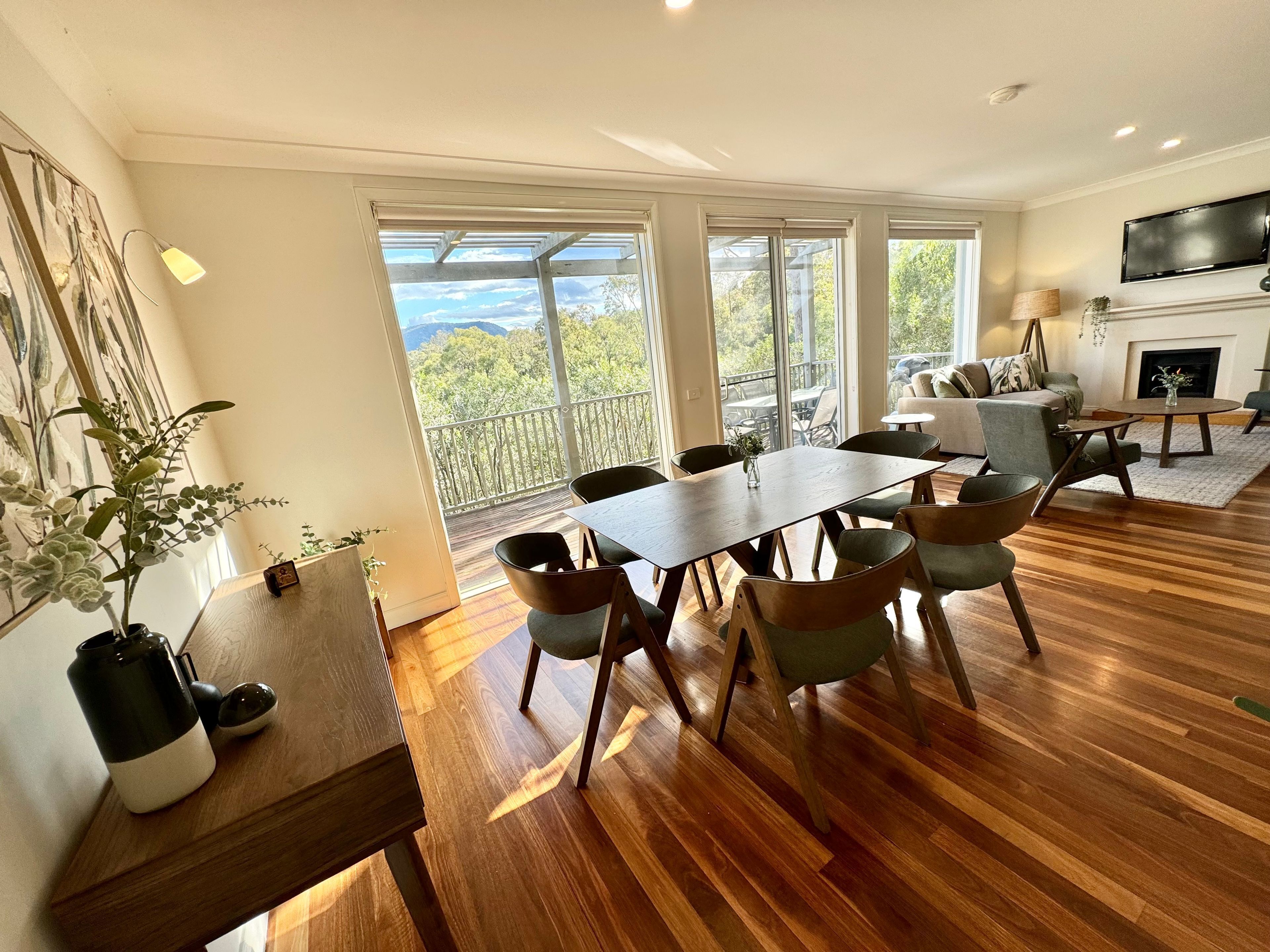 A spacious living area with a dining table, chairs, a sofa, and a fireplace.