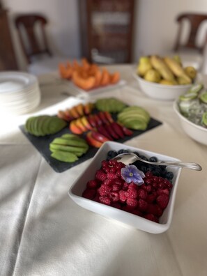 A table with various fruit platters and a bowl of mixed berries. - Burlamacchi Villas (Bagni di Lucca)