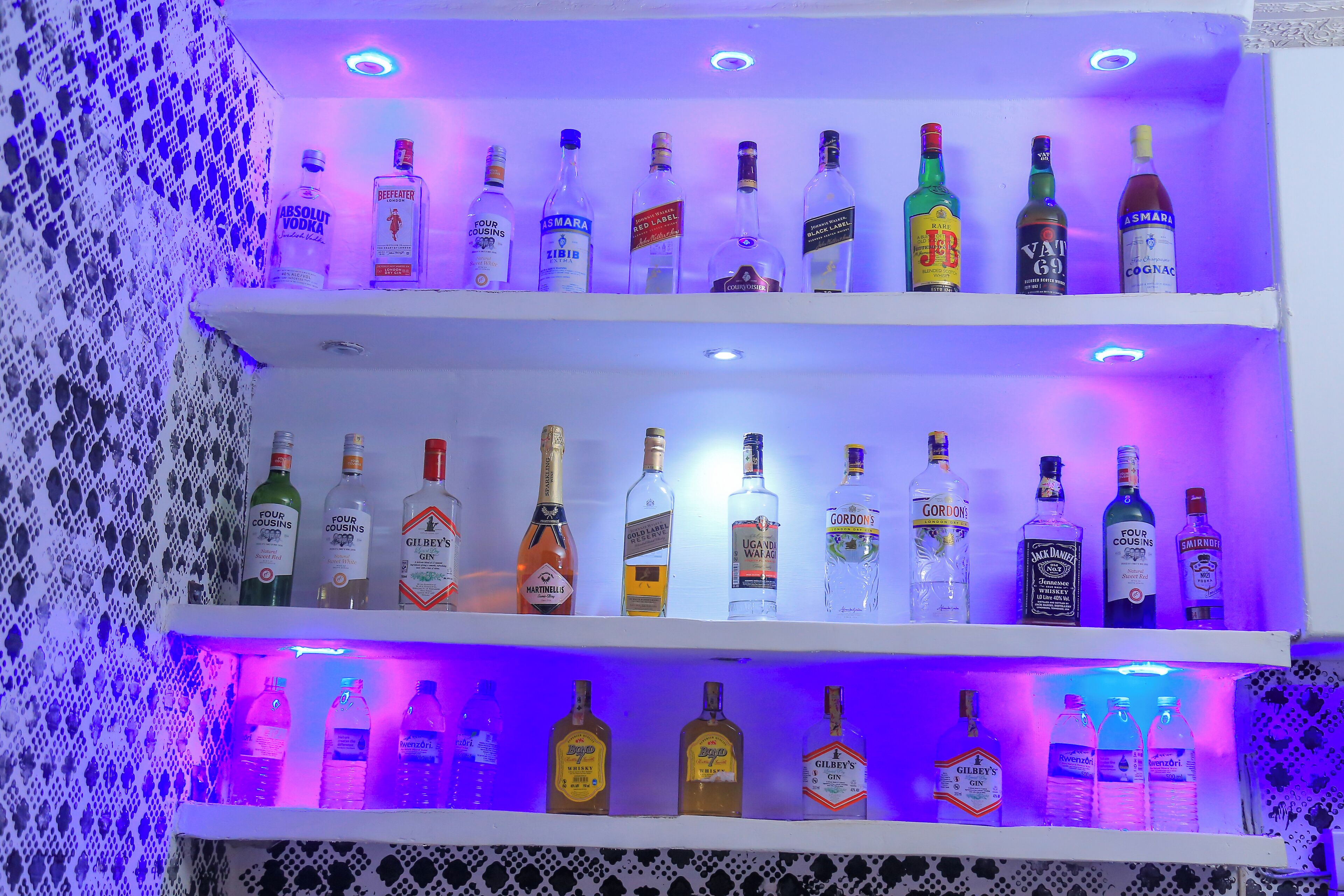 A bar area with shelves of various liquor bottles.