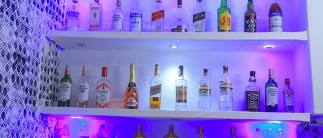 A bar area with shelves of various liquor bottles.