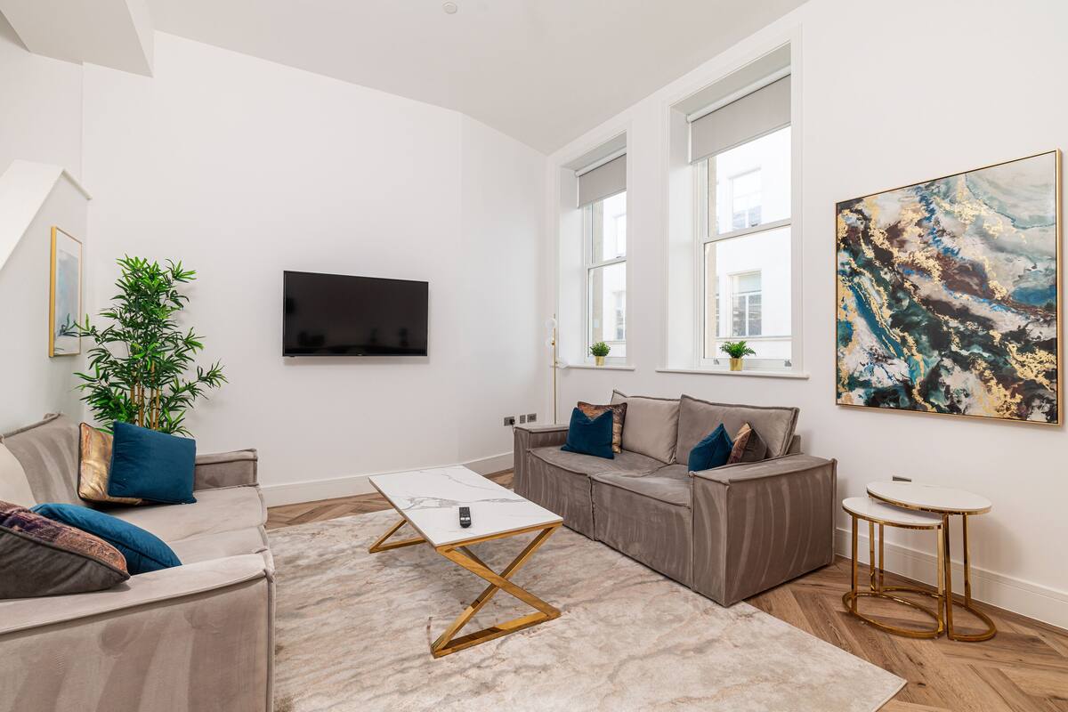 Una sala moderna con un sofá, una mesa de centro y un televisor.