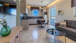 A modern kitchen with a dining area, a sofa, and a coffee table.