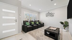 A modern living room with a sofa set, a coffee table, and a potted plant.