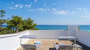 A rooftop terrace with two sun loungers, a table, and a view of the sea. - Villetta Meraviglia With Garden Sea View (Melendugno)