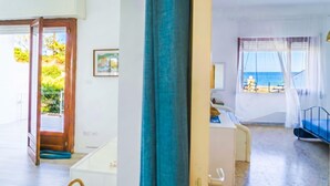 A room with a bed, a desk, and a view of the sea. - Villetta Meraviglia With Garden Sea View (Melendugno)