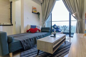 Une chambre moderne avec un lit, une petite table, un canapé et une vue sur l’extérieur.