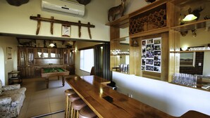 A bar area with stools, a pool table, and a wooden bar counter. - Dasklip Langebaan 8-sleeper (Langebaan)