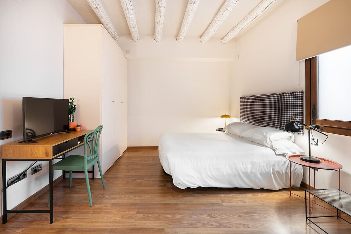 Une petite pièce comprenant un lit, un bureau et une chaise.