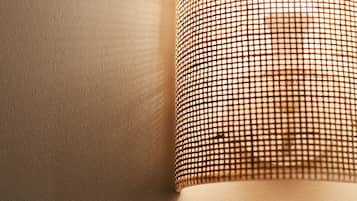 A close-up of a textured wall with a patterned light fixture.
