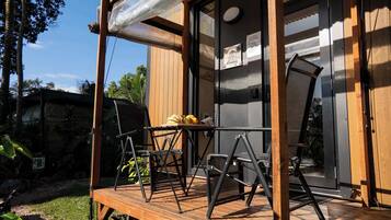 Un patio in legno con mobili da esterno, una porta vetrata e un cartello che indica un ristorante.