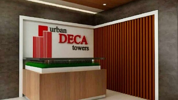 A reception desk with a sign for 'urban DECA towers'.