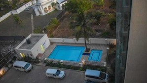 Luftaufnahme eines Wohngebiets mit Schwimmbad, parkenden Fahrzeugen und einem Gebäude mit Kuppeldach.