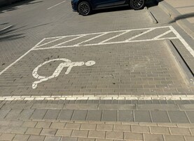 A parking area with a disabled parking space marked by a wheelchair symbol.