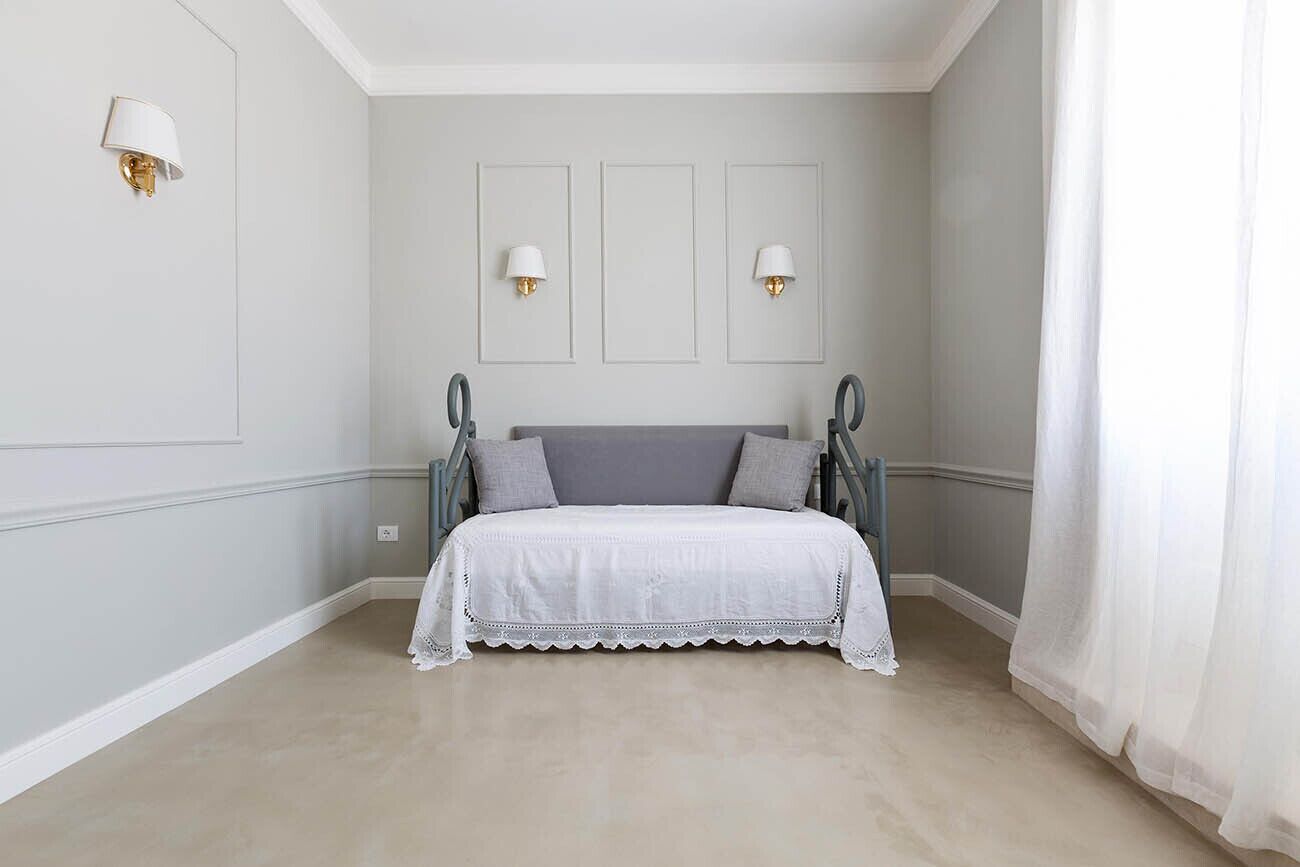 Un dormitorio con cama, dos lámparas de pared y una ventana con cortinas.
