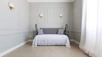 Un dormitorio con cama, dos lámparas de pared y una ventana con cortinas.