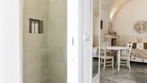 A modern bathroom with a glass shower enclosure and a white sink. - 19 White Luxury Suite With Jacuzzi by Wonderful Italy (Ostuni)
