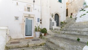 A narrow stone staircase leading to a white building with a door and potted plants. - 19 White Luxury Suite With Jacuzzi by Wonderful Italy (Ostuni)