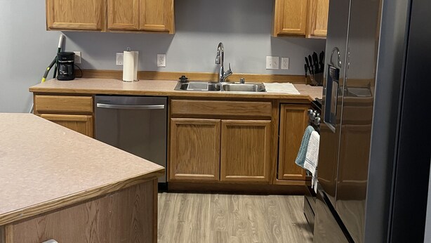 Una cocina moderna con armarios de madera, un refrigerador de acero inoxidable y un lavavajillas integrado.