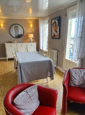 Relax in this inviting space with a dining area, comfortable armchair, and stylish dresser.