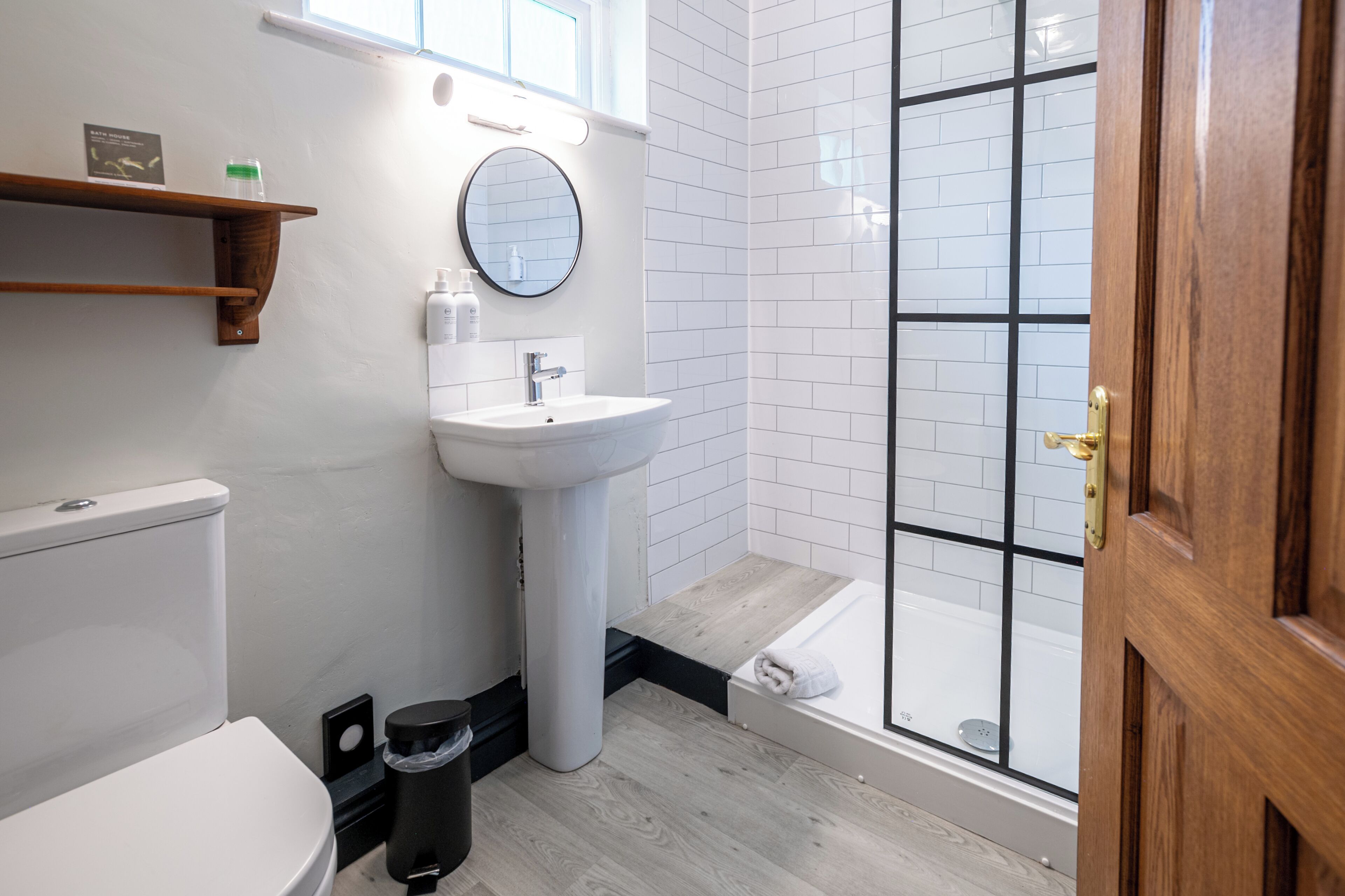 A modern bathroom with a toilet, sink, and shower.