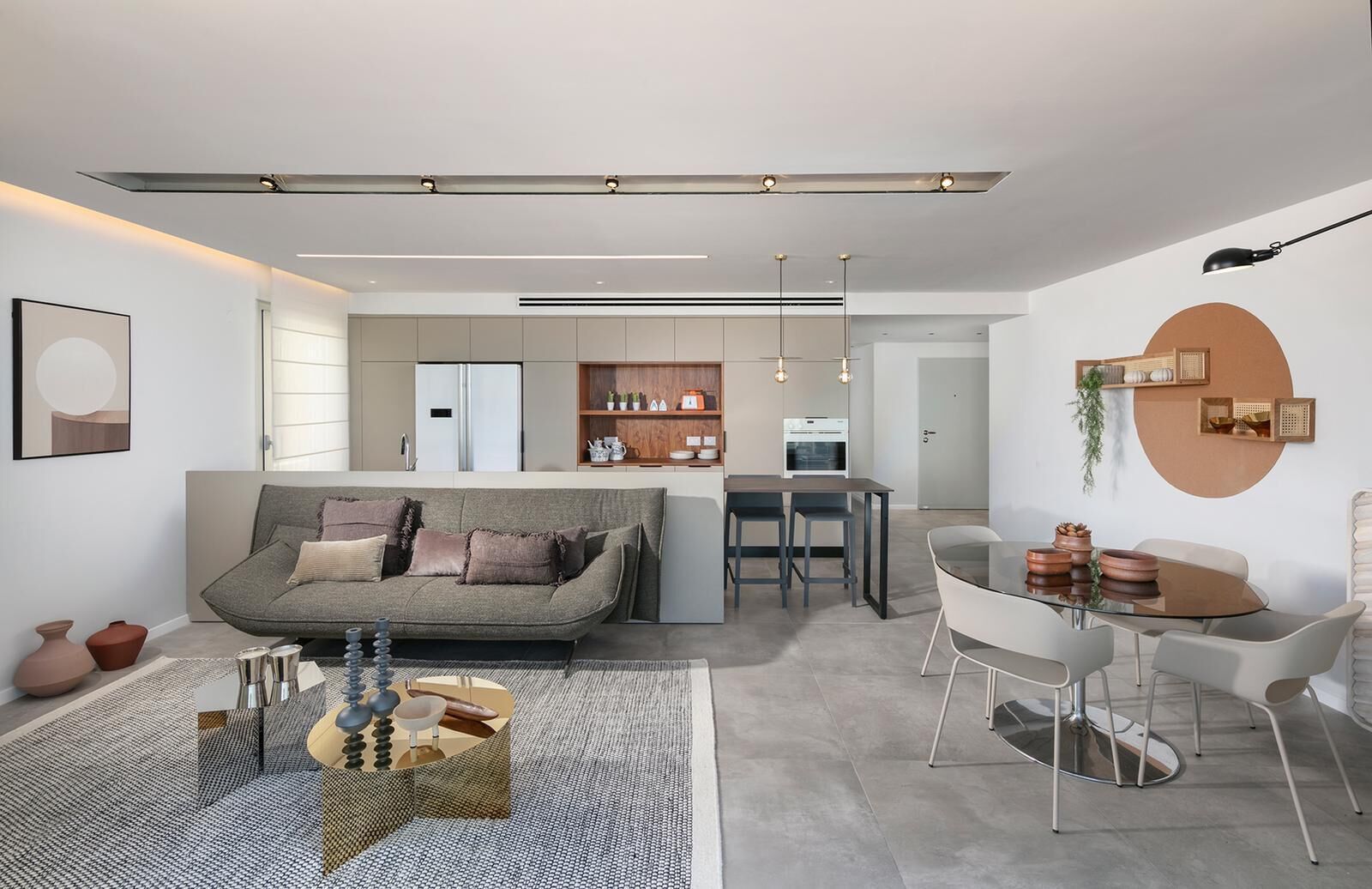 Una sala de estar moderna con sofá, mesa de comedor y zona de cocina.