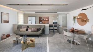 Un salon moderne comprenant un canapé, une table à manger et un coin cuisine.